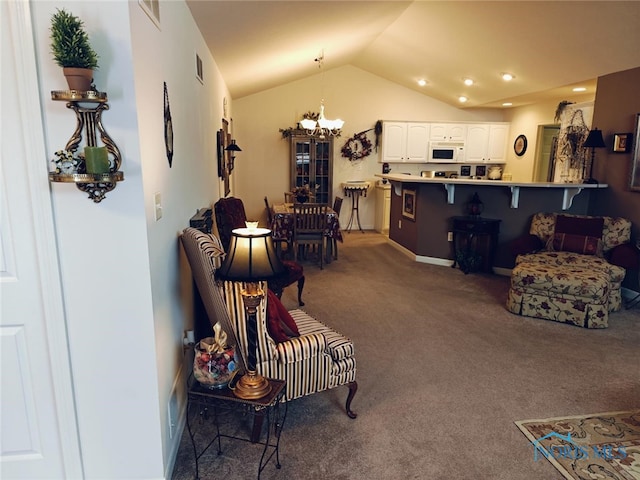 carpeted living area with visible vents, lofted ceiling, and a chandelier