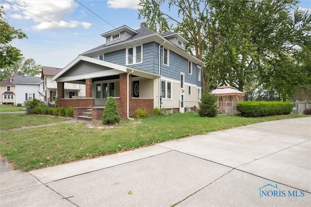 view of front of home with a porch and a front yard