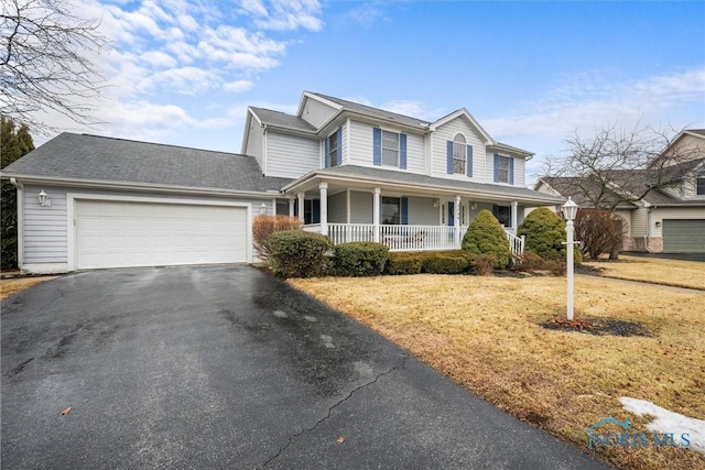 view of front of house with a garage, covered porch, and driveway