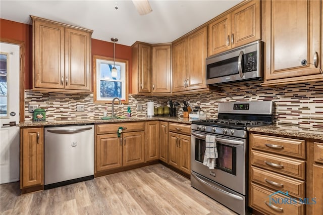 615 Lincolnshire Ln, Findlay, OH 45840 - kitchen featuring sink, hanging light fixtures, dark stone counters, and appliances with stainless steel finishes
