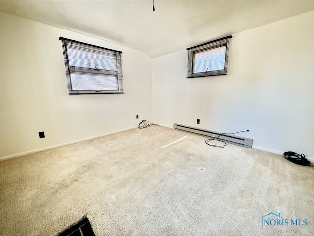 carpeted empty room featuring baseboard heating