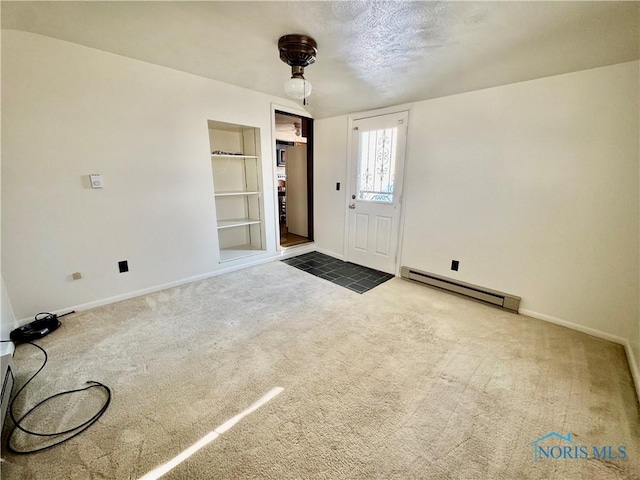 interior space featuring carpet and a baseboard heating unit