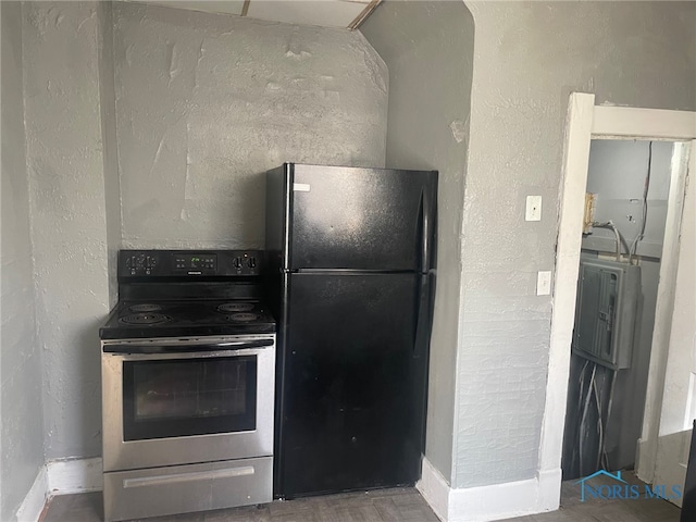 kitchen with black refrigerator and stainless steel range with electric cooktop