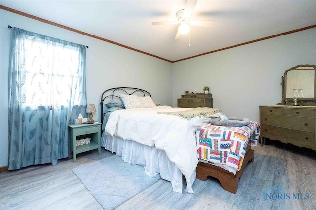 bedroom featuring hardwood / wood-style flooring, ornamental molding, and ceiling fan