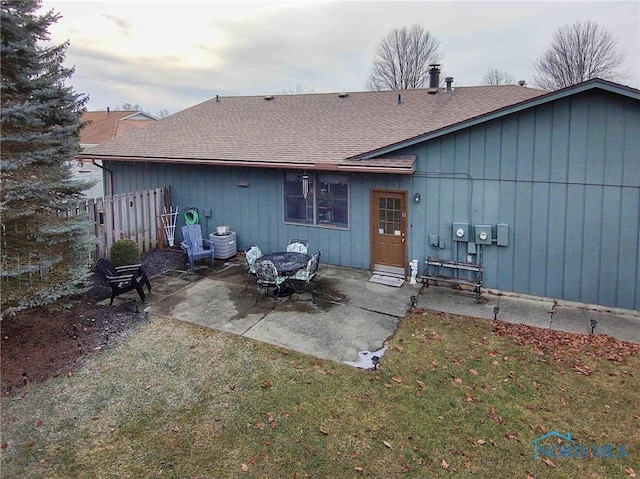 back of house with a patio and a lawn