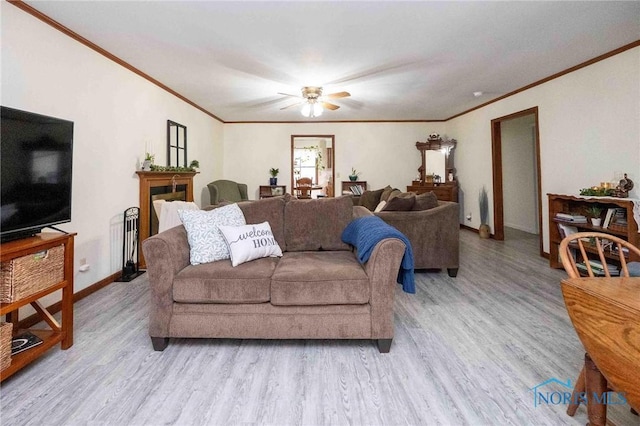 living room with crown molding, ceiling fan, and light hardwood / wood-style flooring