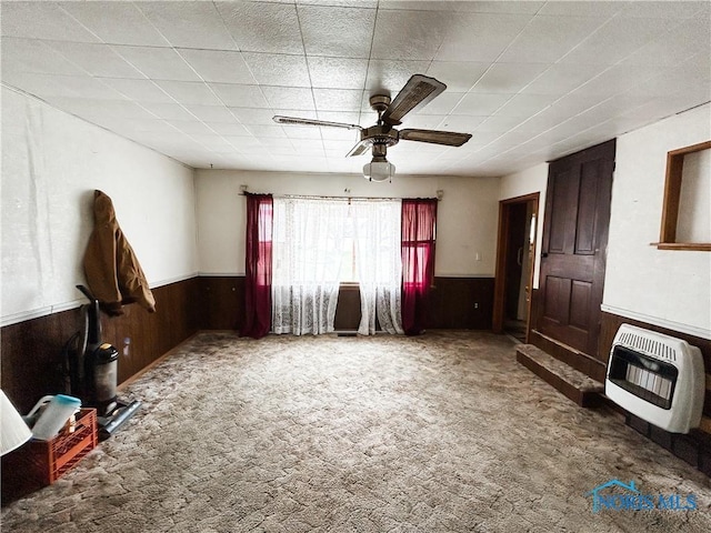 12356 Sylvania Metamora Rd, Berkey, OH 43504 - unfurnished living room featuring ceiling fan, carpet flooring, heating unit, and wooden walls
