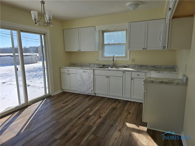 kitchen with pendant lighting, sink, dishwasher, white cabinetry, and dark hardwood / wood-style flooring