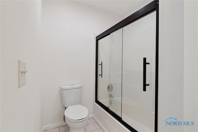 bathroom featuring toilet, bath / shower combo with glass door, and tile patterned flooring