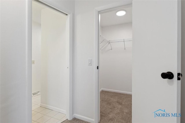 walk in closet featuring light colored carpet