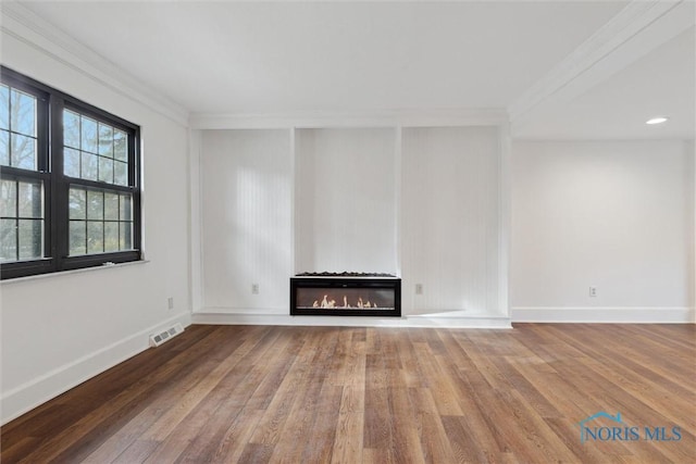 unfurnished living room featuring hardwood / wood-style floors and ornamental molding