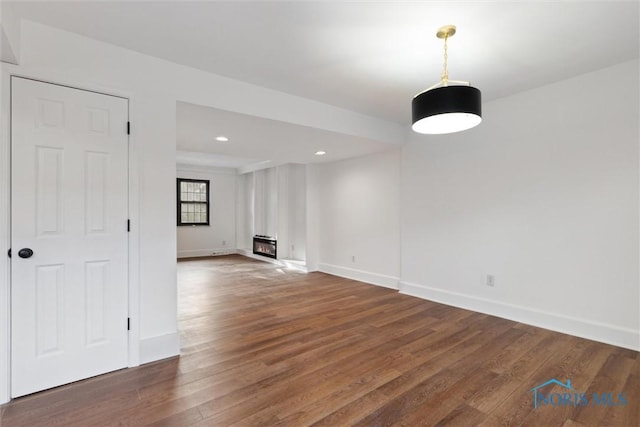 spare room with heating unit and dark hardwood / wood-style flooring