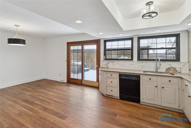 kitchen featuring sink, decorative light fixtures, black dishwasher, hardwood / wood-style floors, and white cabinets