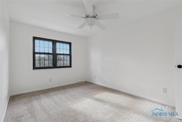 carpeted spare room featuring ceiling fan