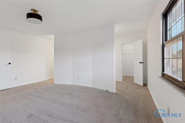 empty room featuring a healthy amount of sunlight and light carpet