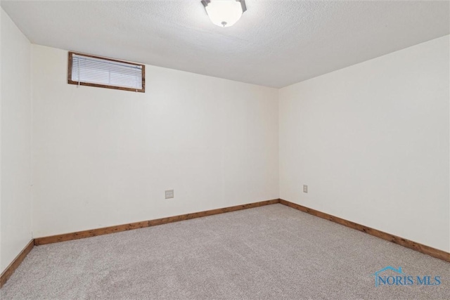 empty room with light colored carpet and a textured ceiling