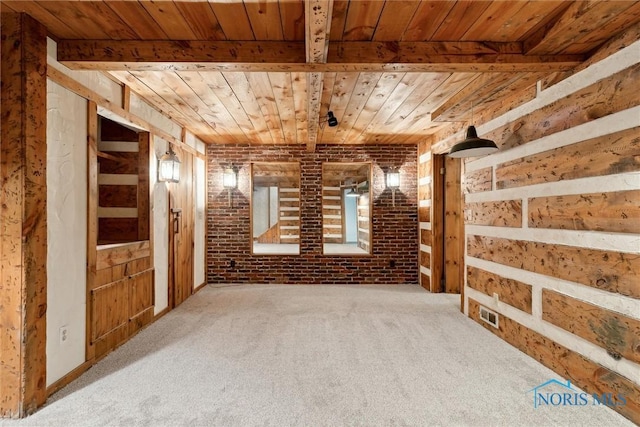 carpeted empty room with wood ceiling and brick wall