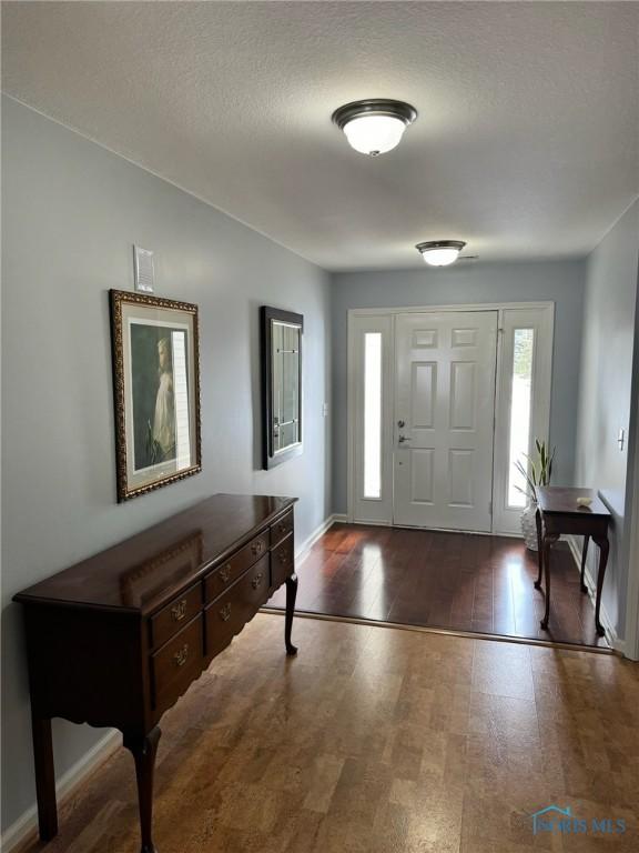 entrance foyer featuring dark hardwood / wood-style floors and a textured ceiling