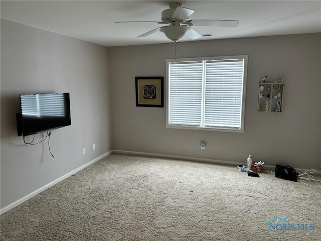 carpeted spare room with ceiling fan