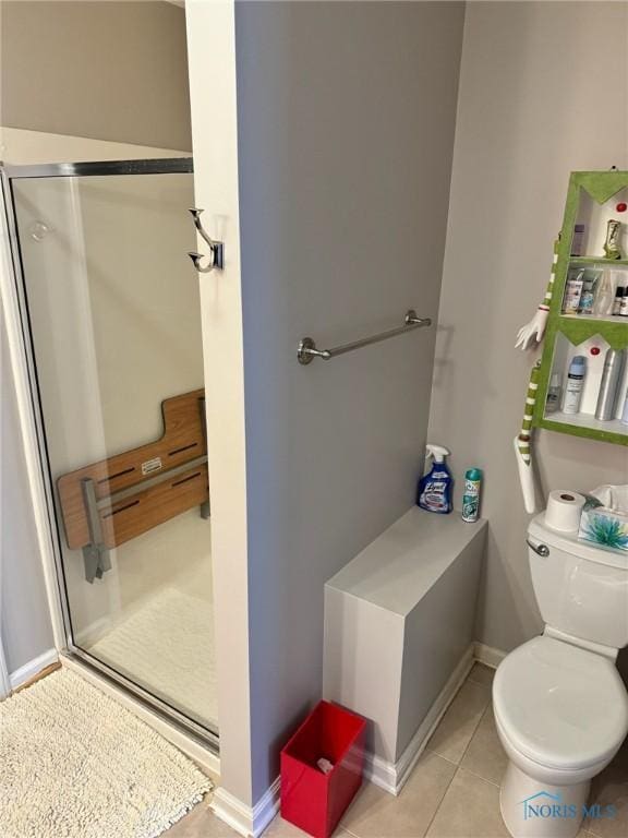 bathroom featuring tile patterned floors, toilet, and walk in shower