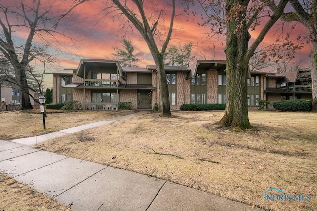 view of property featuring brick siding and a balcony