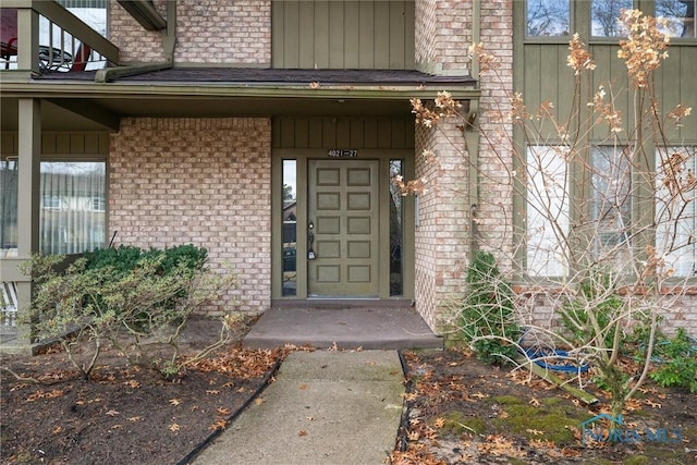 entrance to property featuring brick siding