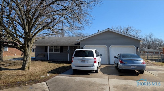 single story home featuring concrete driveway and an attached garage