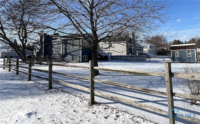 yard layered in snow featuring a storage shed