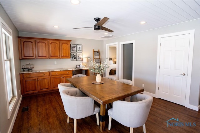 dining space with dark hardwood / wood-style floors and ceiling fan