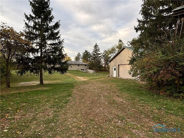 view of yard with a garage and an outbuilding