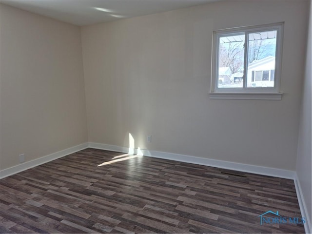 empty room with dark wood-type flooring