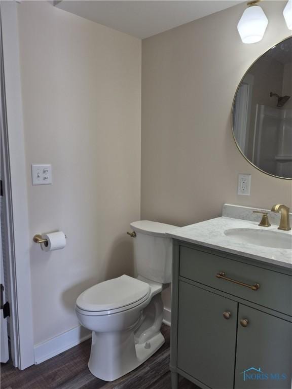 bathroom with toilet, hardwood / wood-style flooring, and vanity