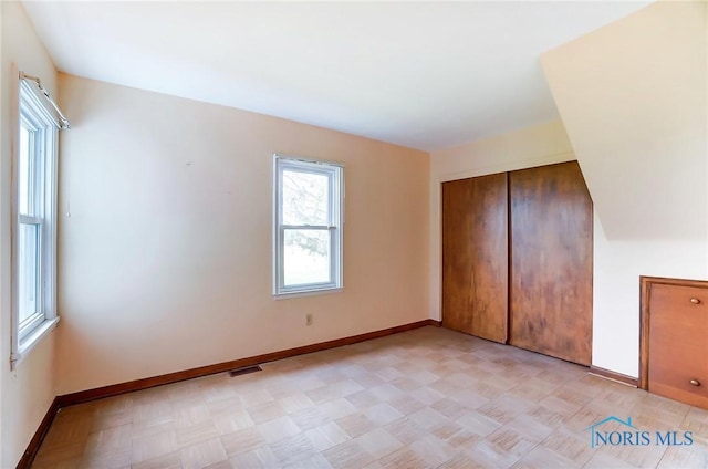 unfurnished bedroom with a closet and light parquet floors