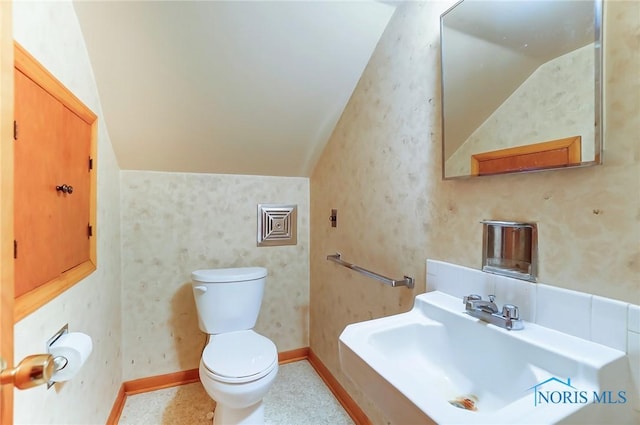 bathroom featuring lofted ceiling, sink, and toilet