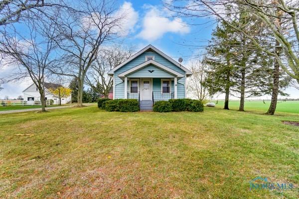 bungalow featuring covered porch and a front yard