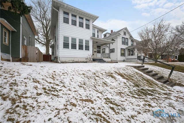 view of snow covered rear of property