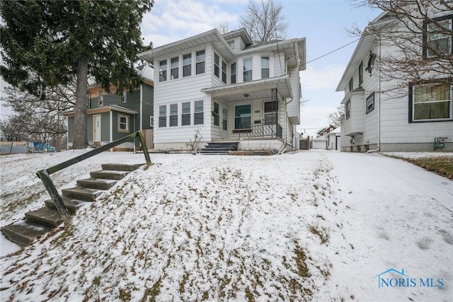 snow covered house with covered porch