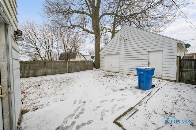 yard layered in snow featuring a garage