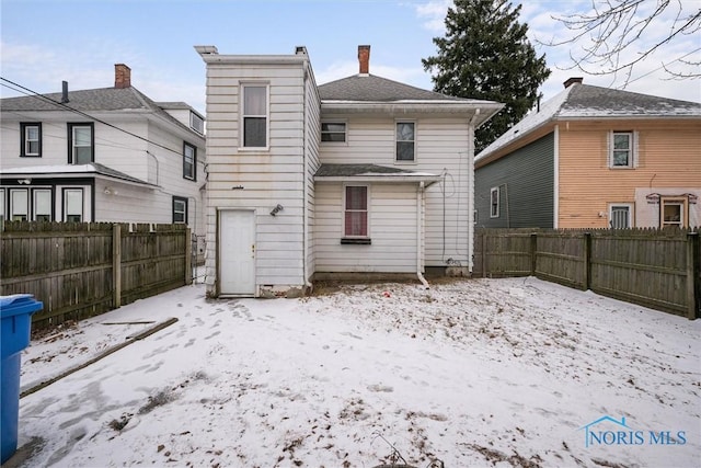 view of snow covered back of property