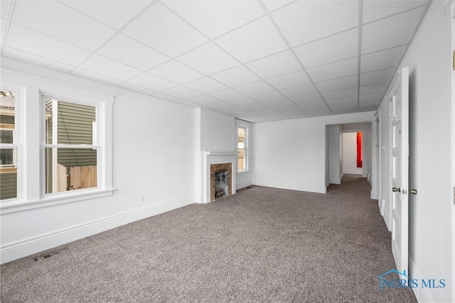 unfurnished living room featuring a drop ceiling and carpet floors