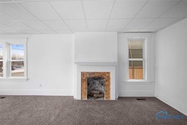 unfurnished living room with carpet and a paneled ceiling