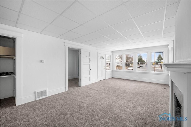 unfurnished living room with a paneled ceiling and carpet floors