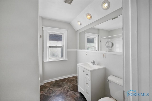 bathroom with toilet, lofted ceiling, and vanity