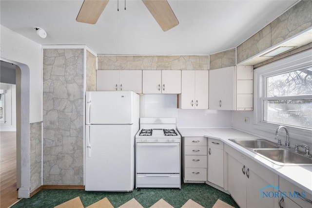 kitchen with ceiling fan, sink, white appliances, and white cabinets