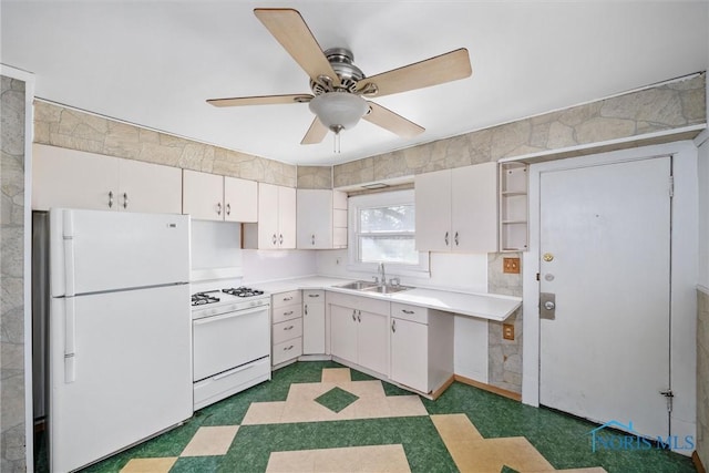 kitchen with sink, white appliances, white cabinets, and ceiling fan