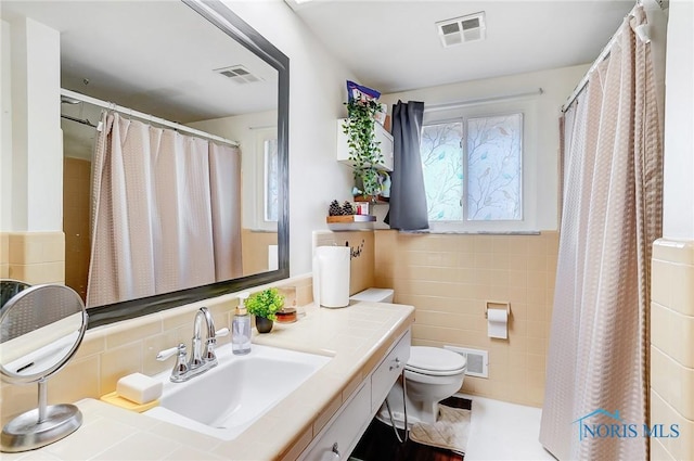 4811 Larkhaven Dr, Toledo, OH 43623 - full bath with tile walls, toilet, vanity, a shower with curtain, and wainscoting