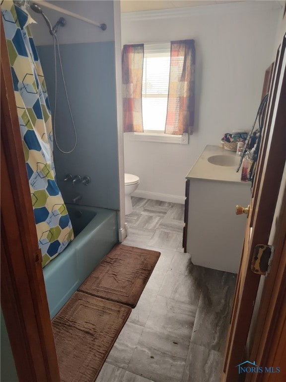 bathroom with baseboards, vanity, toilet, and shower / bath combo with shower curtain