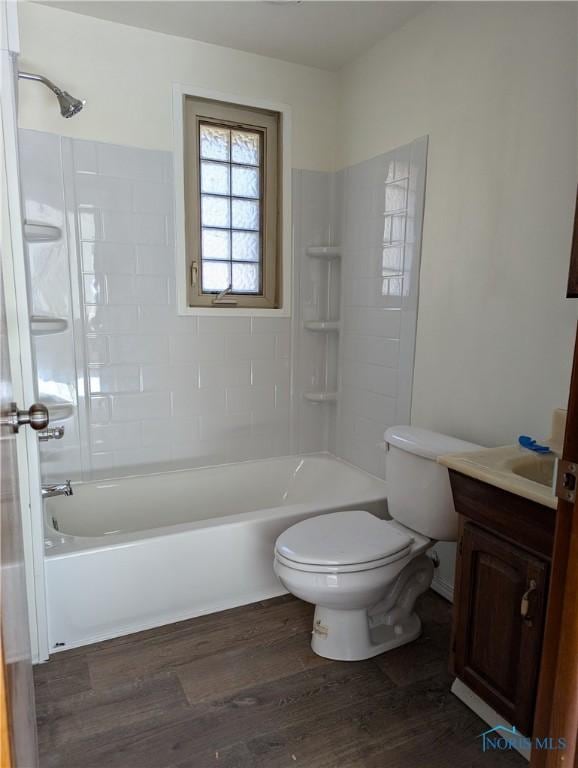 full bathroom featuring hardwood / wood-style floors, toilet, vanity, and tiled shower / bath