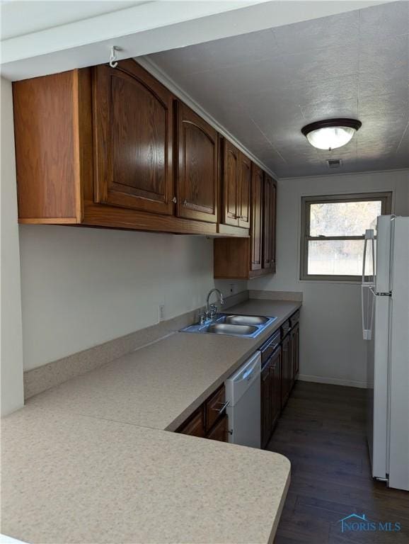 kitchen featuring white appliances, sink, and dark hardwood / wood-style floors