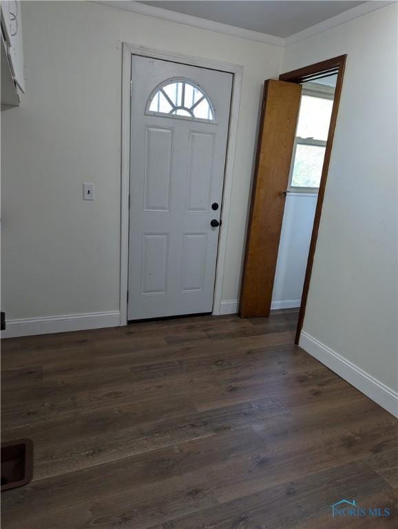 foyer entrance with crown molding and dark hardwood / wood-style floors